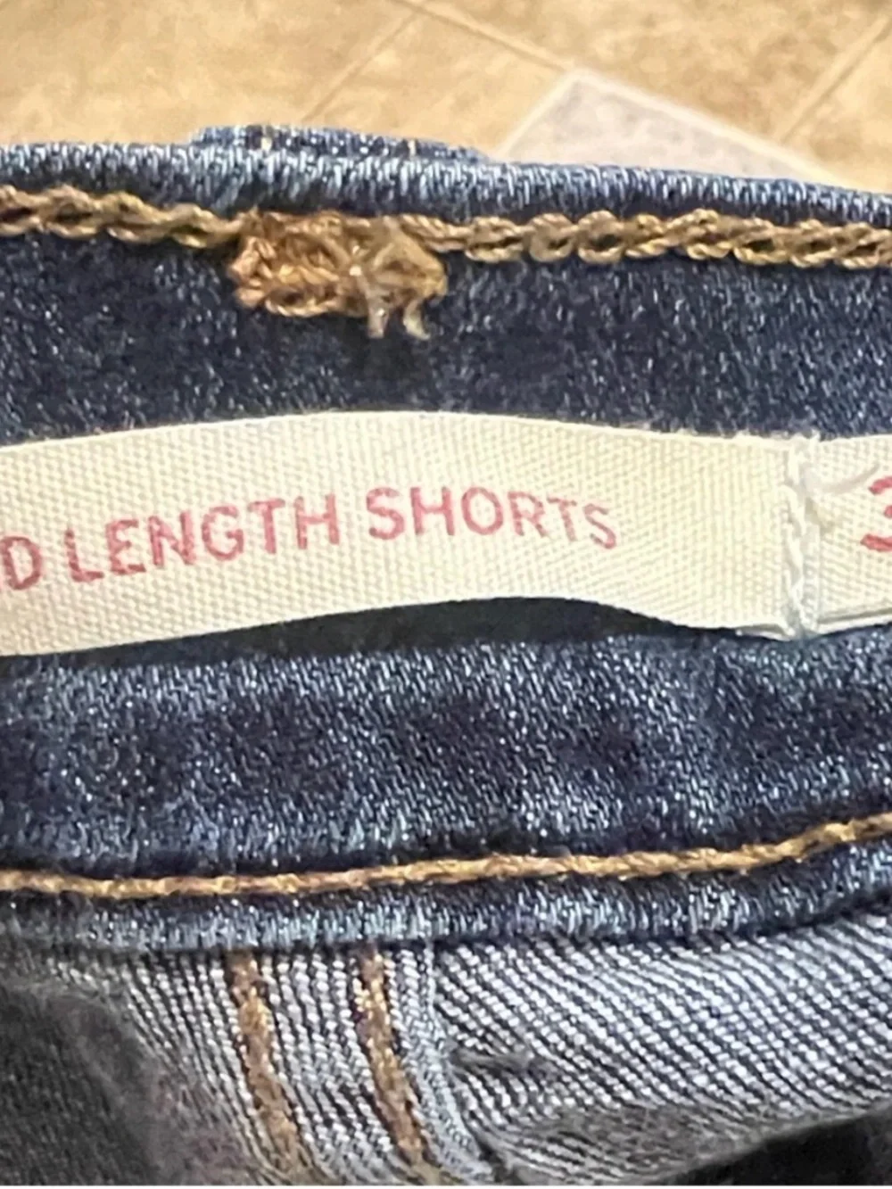 Levi's Dark Blue Denim with Tan Stitch Button Close-Up - Picture 6 of 9